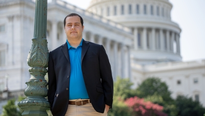RSS-DC student, Adam Halperin, leaning on pole in front of Capitol